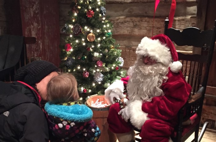 Image of Santa Clause handing a small child a candycane