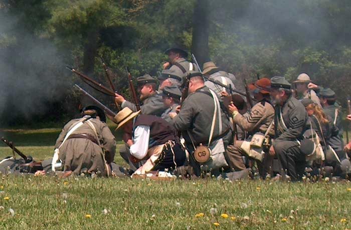 Image of Civil War Reenactors in a group firing their rifles