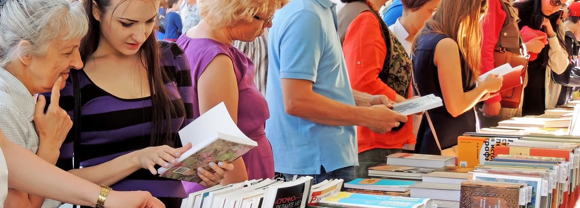 Image of people looking at and holding books at a book fair