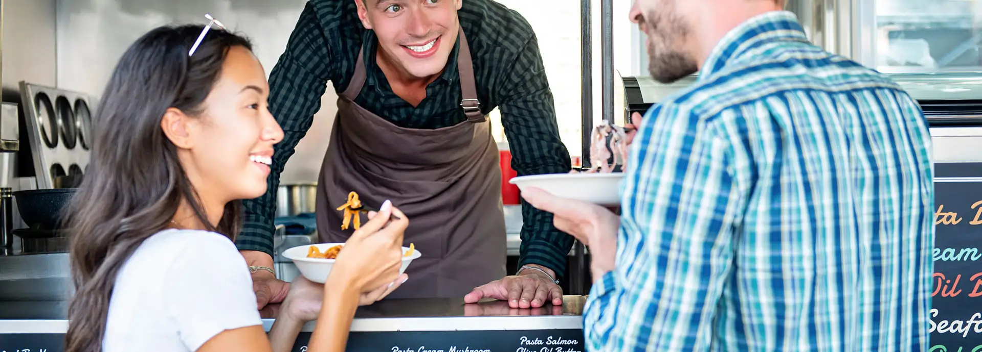 Image of two people receiving their food from a food truck vendor