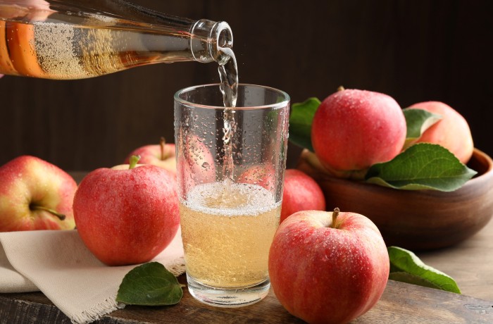 Image of apples and bottle pouring ale into a glass